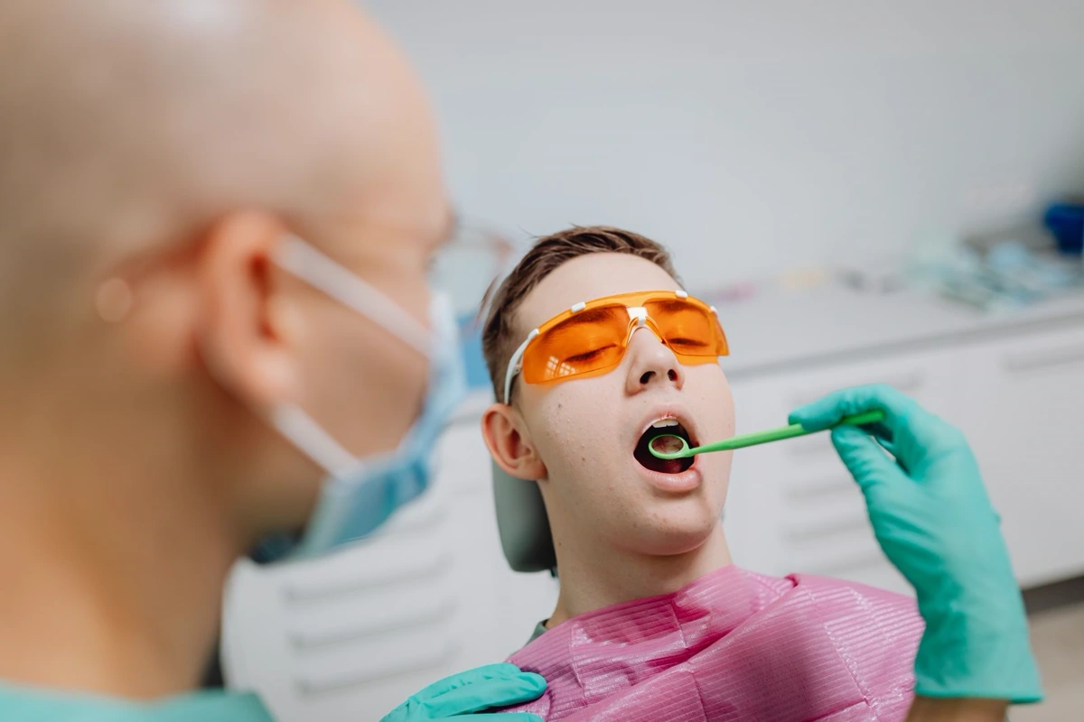 A young patient wearing protective glasses during a dental check-up