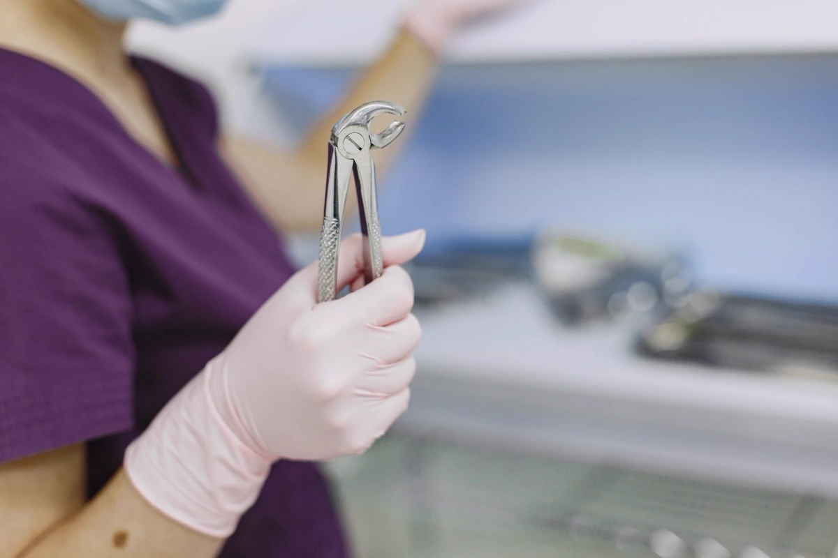 Clinician holding dental extraction forceps